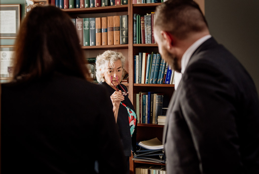 Lawyer speaking with clients in an office library